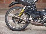 a black motorcycle parked in front of a brick wall