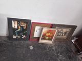 three framed pictures on the floor next to a piano