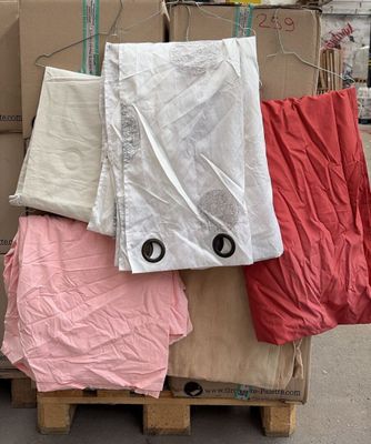 une pile de cartons posés sur une palette et recouverts d'une bâche