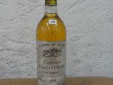 une bouteille de champagne posée sur une table en bois, avec un mur blanc en arrière-plan