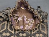 a close up of a purse on a table with a gray background