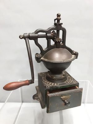 un vieux moulin à café exposé dans une vitrine
