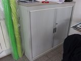 une armoire blanche surmontée d'un rideau vert