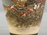 a vase with a painting on it on a table