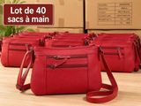 four red purses sitting on top of a table with boxes in the background