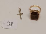 deux bagues et une croix posées sur une table blanche