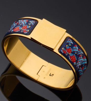 a close up of a gold bracelet with a blue and red design