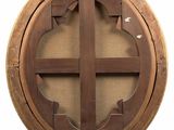 an image of a round wooden window with a cross on it
