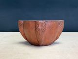 une image représentant un bol rouge posé sur une table en bois