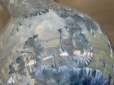 a glass vase with blue flowers in it on a table