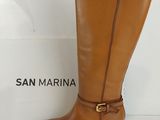 tan leather boots with buckles and a gold buckle on the heel