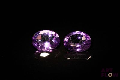 une paire d'améthystes violettes posées sur une surface noire