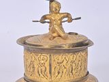 une figurine ancienne en laiton surmontée d'une tasse