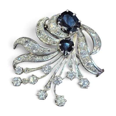une photo d'une broche en noir et blanc sertie de diamants