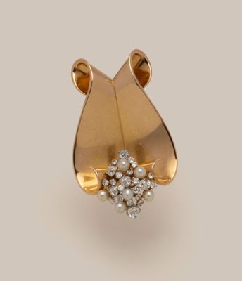 a close up of a gold and diamond broochle on a white background