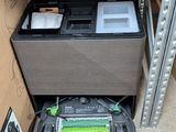 a black and gray robot sitting on the floor next to a box