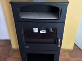 a small black stove in the corner of a room