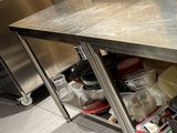 une grande table en inox sur laquelle sont disposés tout un tas de plats