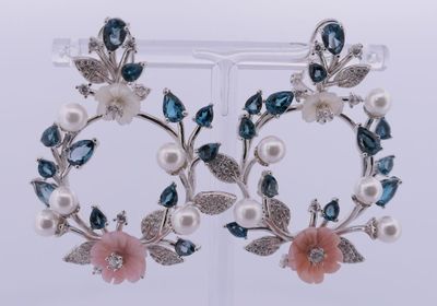 une paire de boucles d'oreilles bleues et blanches ornées de fleurs et de feuilles