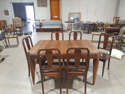 des tables et des chaises dans une pièce où l'on aperçoit de nombreux meubles à l'arrière-plan
