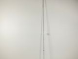 un grand poteau dans une pièce, avec un mur blanc derrière lui