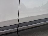 the side of a white car with a crack in the side of it