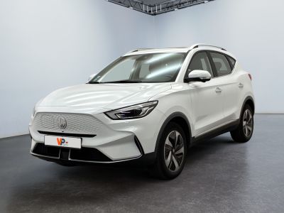 un SUV blanc garé dans une grande pièce au sol noir