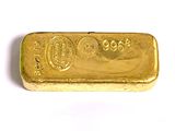 une barre d'or posée sur une surface blanche