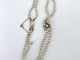 a close up of a necklace with a bow and arrow on it