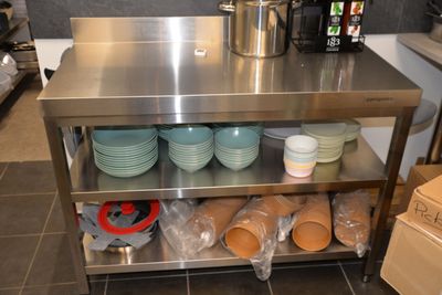 a stainless steel table with plates and bowls on it