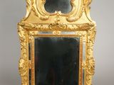 a gold frame with a mirror in it on a table