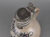 a small blue and white vase with a silver lid