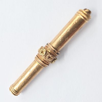 a gold pen that is laying on a white surface