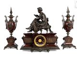 une statue représentant une femme assise sur une table, à côté de trois vases et d'une horloge