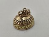 a gold plated charm with a bird on top of it