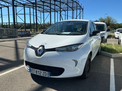 la voiture blanche est garée dans le parking à côté du bâtiment