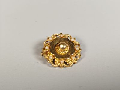 a close up of a gold ring with pearls on a white surface