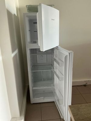 un réfrigérateur blanc dont la porte est ouverte, dans une cuisine