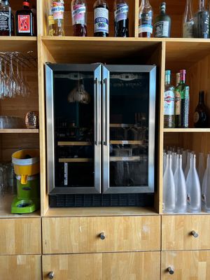 de nombreuses bouteilles et verres sur les étagères de la cuisine