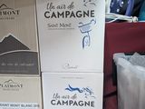 plusieurs cartons de vin posés sur une table à côté d'une table à repasser