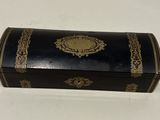 an old black and gold box with a gold trimming on it