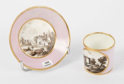 two cups and a saucer with a picture of a town on them