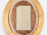 an image of a round mirror with a wooden frame on a white wall