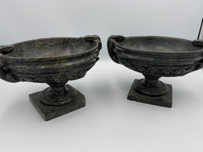 pair of antique cast iron urns on pedestals on a white background