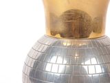 a silver vase with a gold crown on top of it