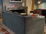 a living room with a couch, chair, table, and fireplace