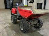 a small red tractor with a big wheel in a warehouse