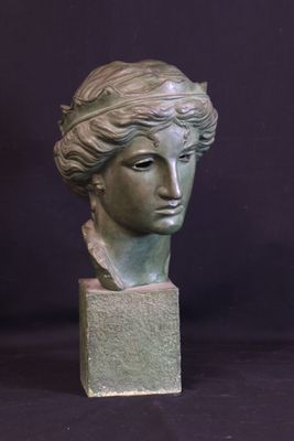 sculpture of a woman ' s head on a block with a black background