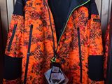 une veste orange et noire accrochée à un portant dans un magasin
