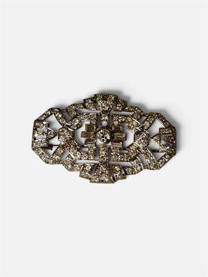 gros plan d'une broche avec des diamants sur un fond blanc